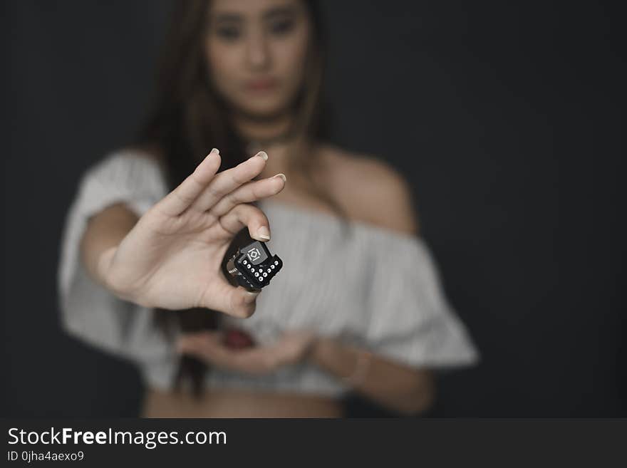 Woman Wearing White Off-shoulder Crop Top Holding Black Cube