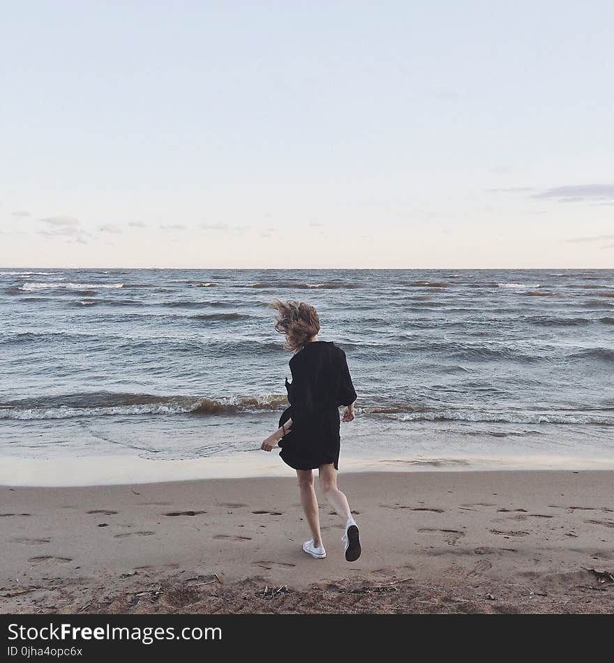 Woman Going Toward the Sea Under Clear Skies