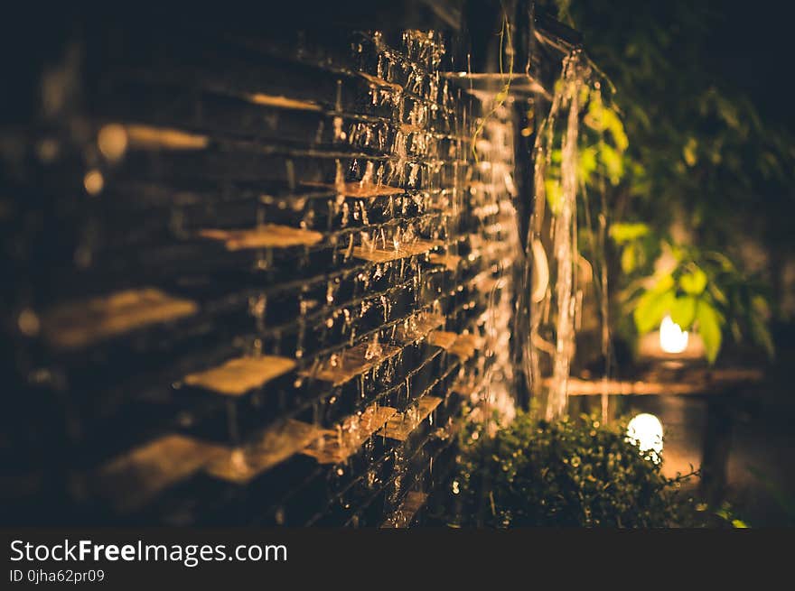 Selective Focus Photography of Brown Brick Wall during Nighttime