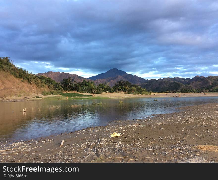 Green and White Mountains Near Body of Water