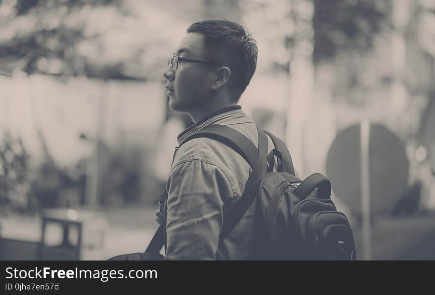 Grayscale Photo of Man Wearing Backpack