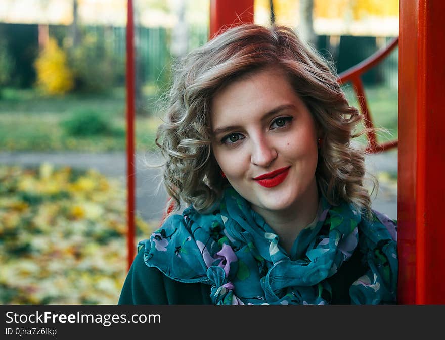 Woman Wearing Blue and Purple Floral Print Scarf Taking a Selfie