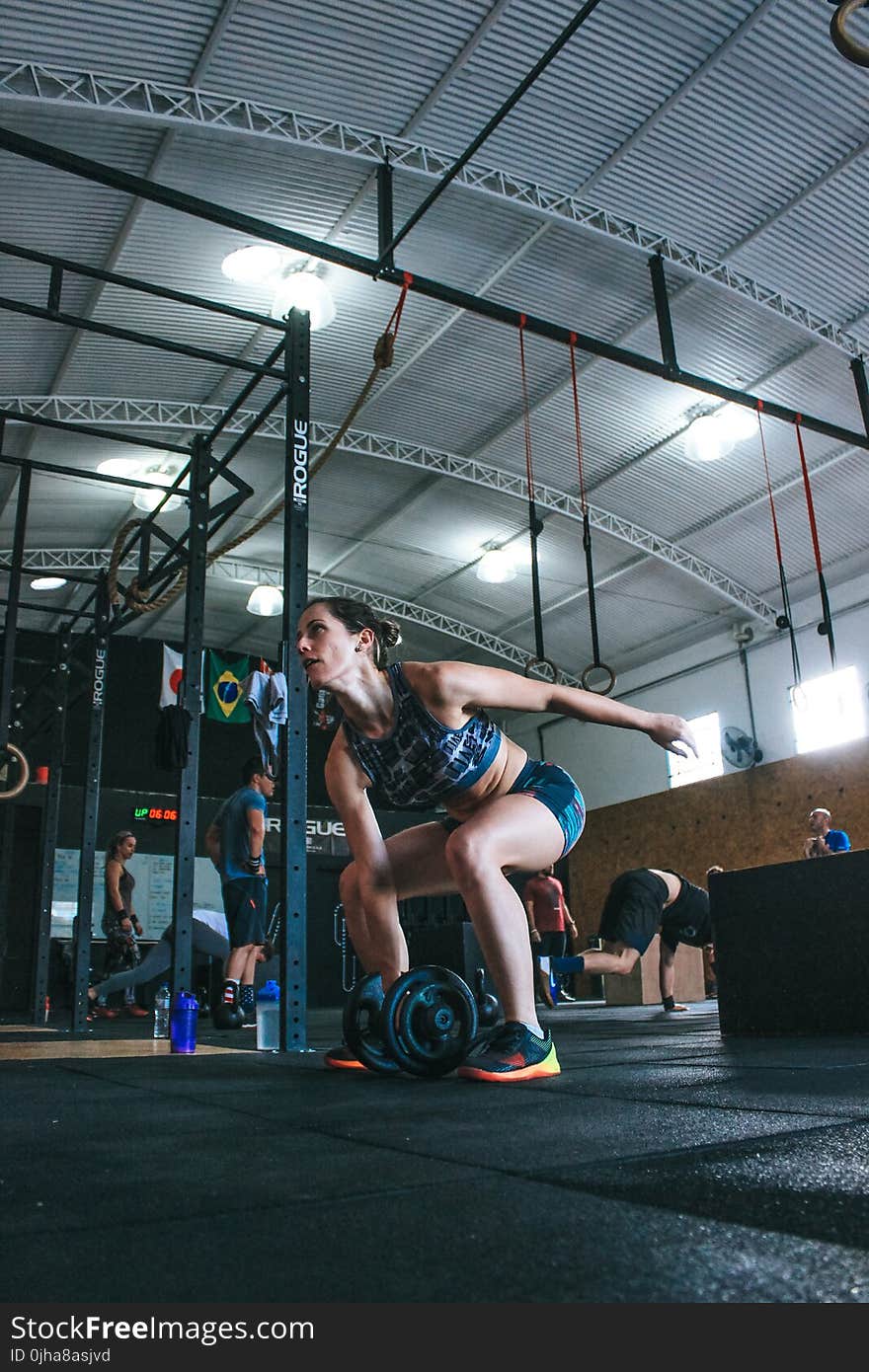 Woman Holding Adjustable Dumbbell With Her Right Hand at Gym