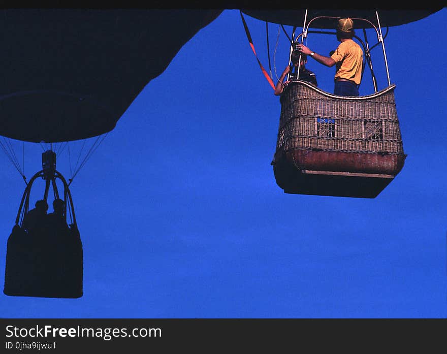 Man Wearing Orange T-shirt Riding on Brown Parachute