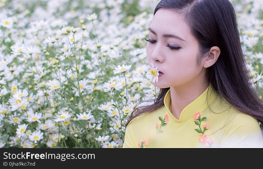 Selective Focus Photography of Woman Kissing White Petaled Flower