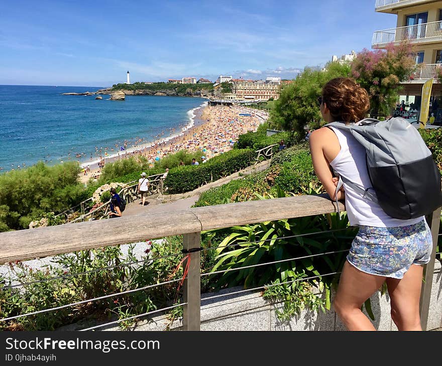 Woman In White Tank Top Leaning On Railing