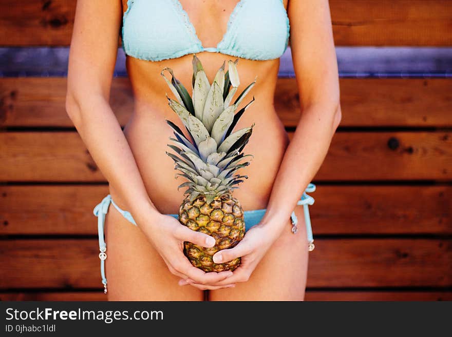 Woman Wearing Teal Bikini Holding Pineapple Fruit