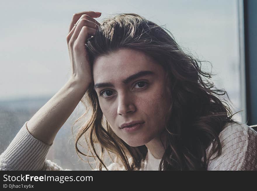 Woman Wearing White Sweater Near Clear Glass Window