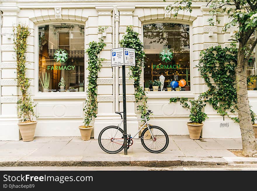 Black and White Bicycle Beside Post