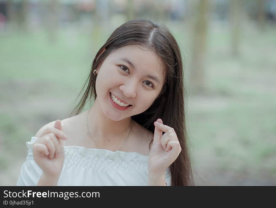 Woman in White Off-shoulder Dress While Taking Selfie