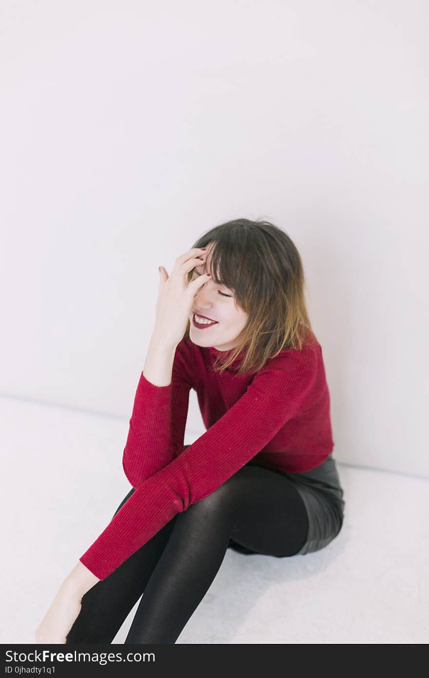 Woman Sitting on the Floor With Left on Her Knees and the Right Hand in Her Face