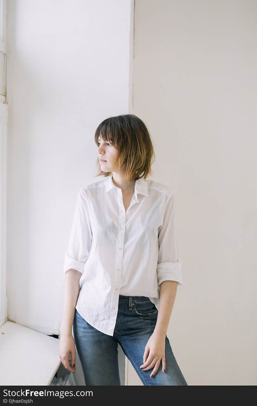 Woman in White Dress Shirt and Blue Jeans