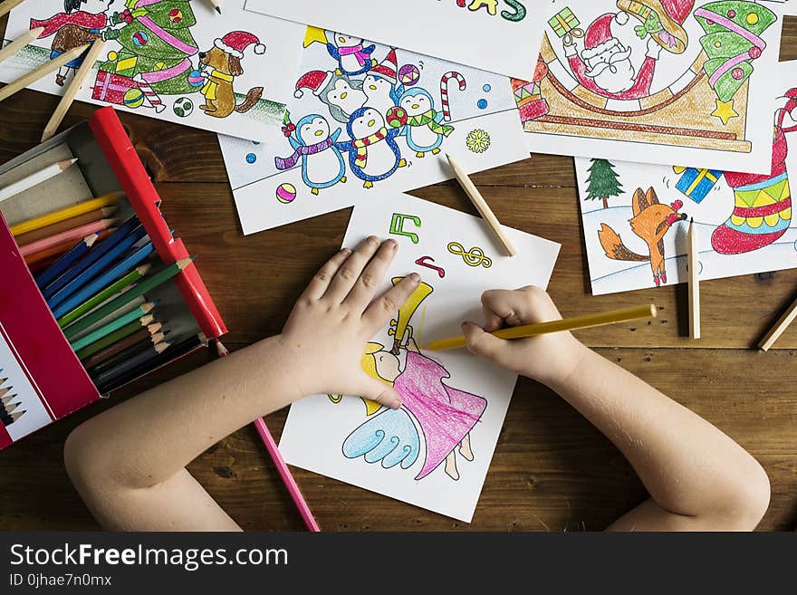 Top Angle Photo of Child Holding Pencil While Drawing Female Angel Playing Wind Instrument