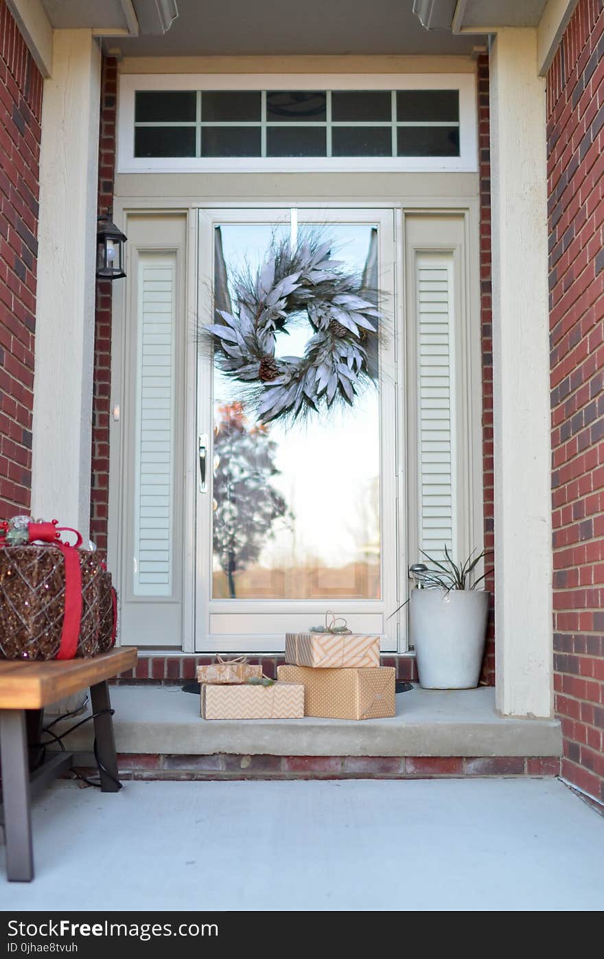 Four Brown Gift Boxes Near a Glass Paneled Door With Wreath