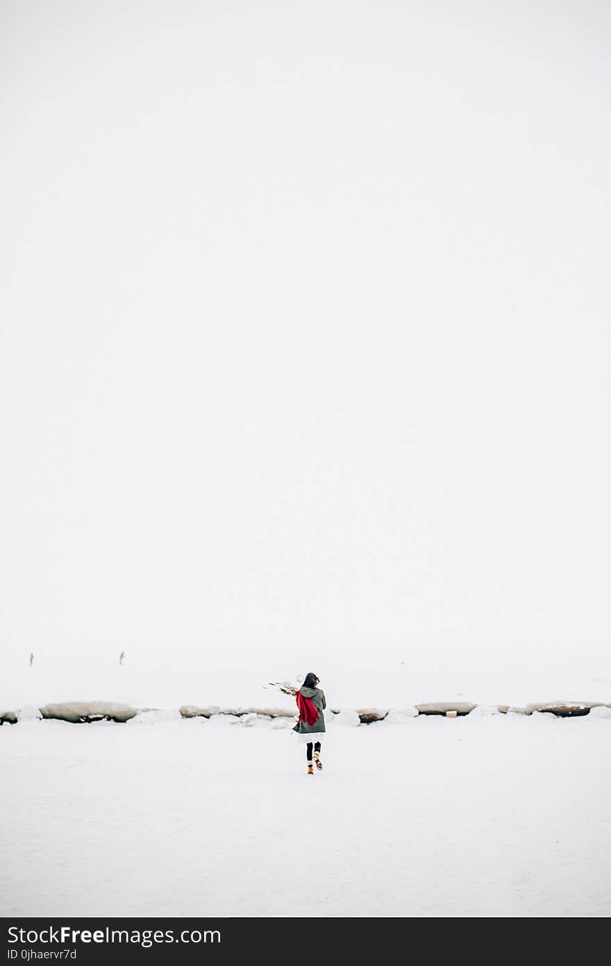 Woman Walking on Snow-covered Field