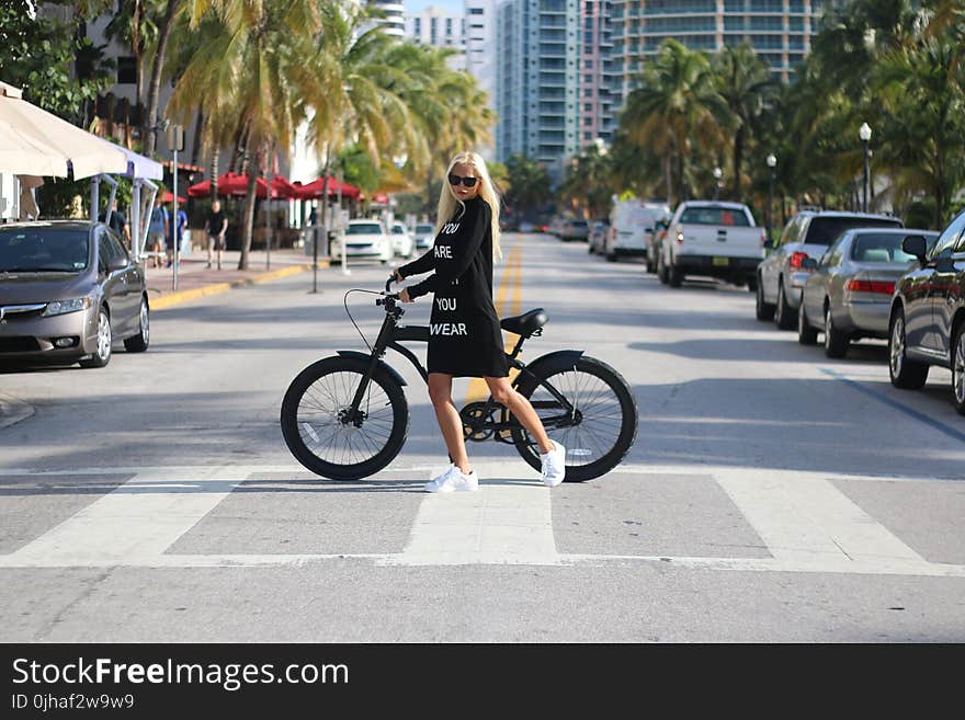 Woman In Black Long Sleeve Shirt Holding Bicycle