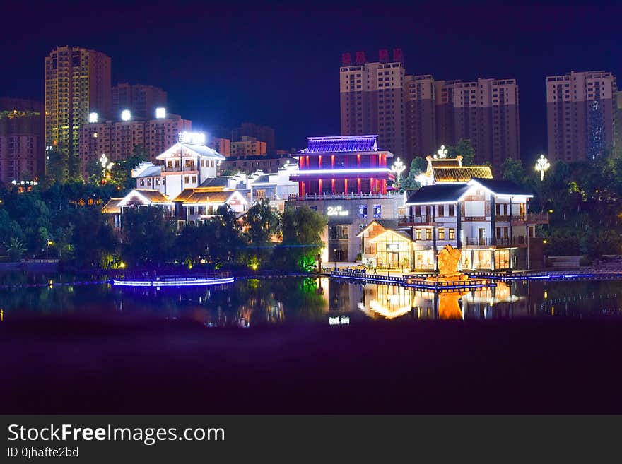 White Concrete House Beside Large Body of Water during Nightime