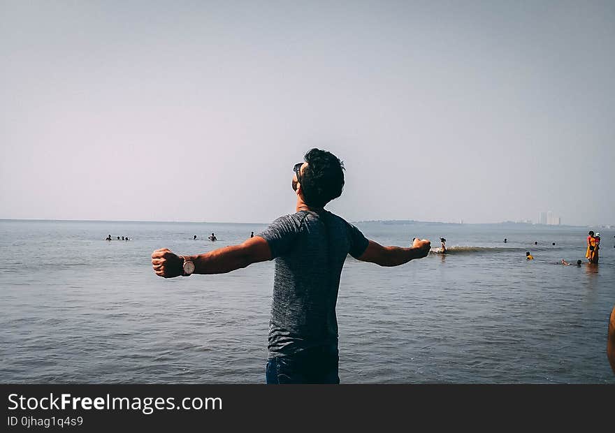 Photo of Man Wearing Gray Shirt Near Sea