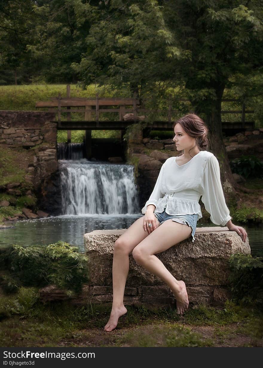 Woman Wearing White Long Sleeve Shirt Sitting Near Waterfalls