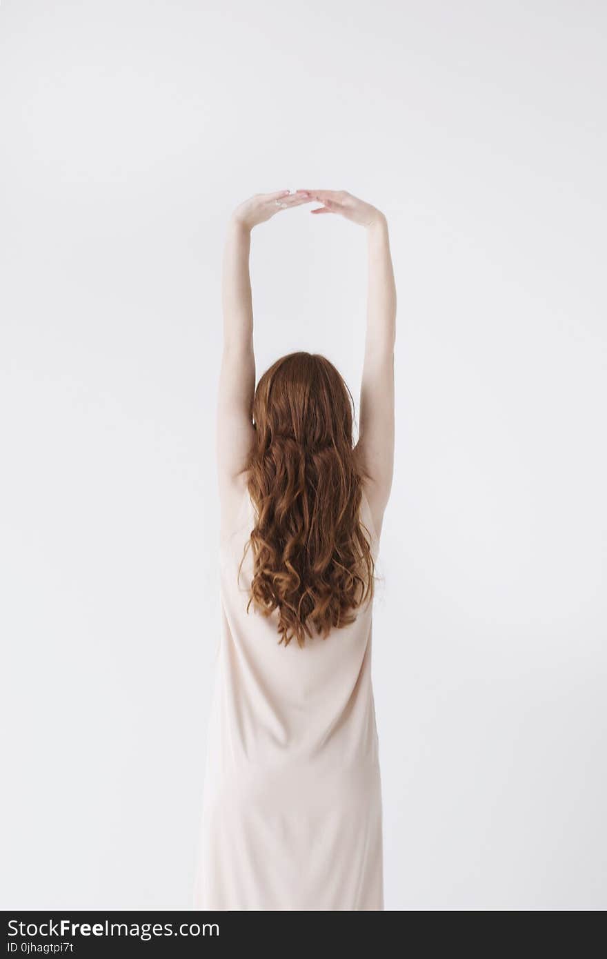 Woman in Beige Dress Stretching Her Hands