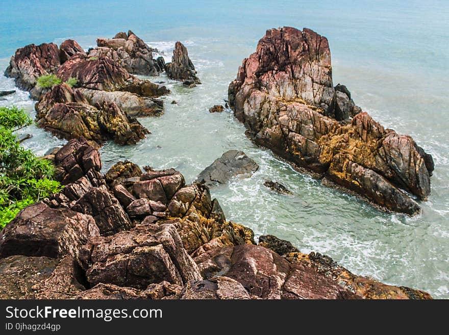 Brown Rock Formations Beside Ocean