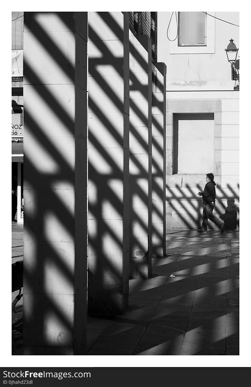 Grayscale Photography of Man Wearing Pullover Hoodie Near Gray Wall