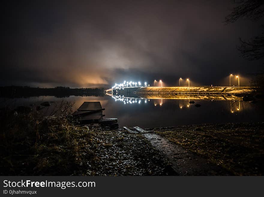 Walls With Lights Near Calm Body of Water at Night Time