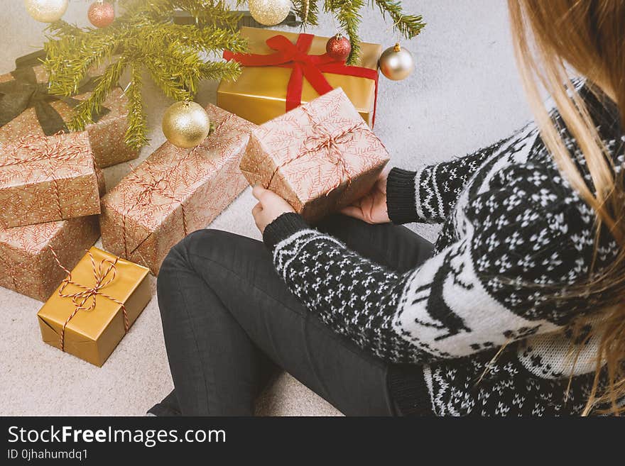 Woman in Sweatshirt and Jeans Holding a Gift Box