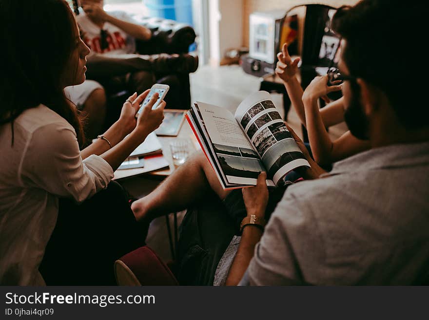 Group of People Reading Book Sitting On Chair