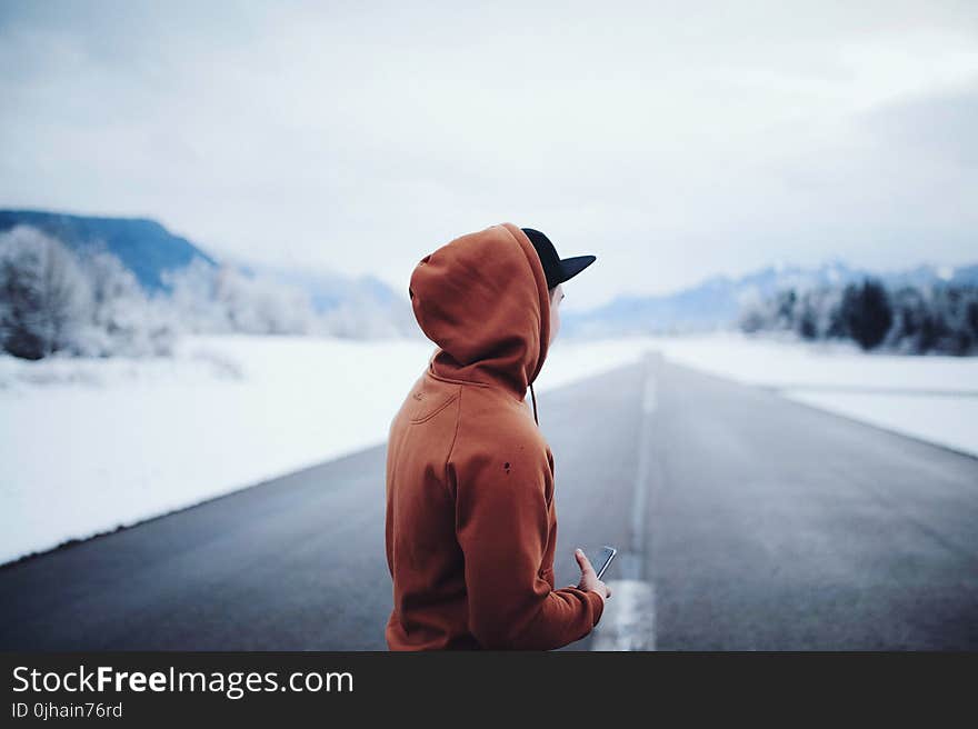 Man Wearing Brown Hoodie in Road