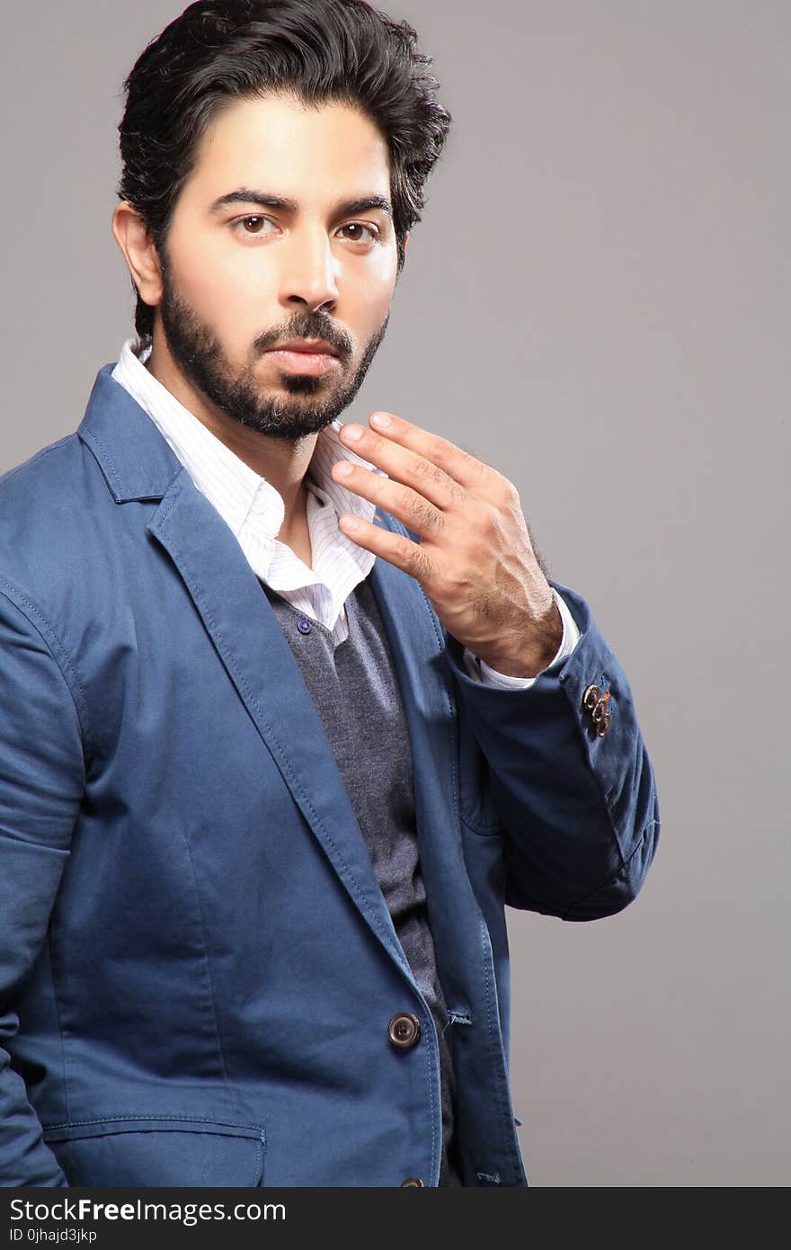 Man About to Touch His Face Wearing Blue Suit