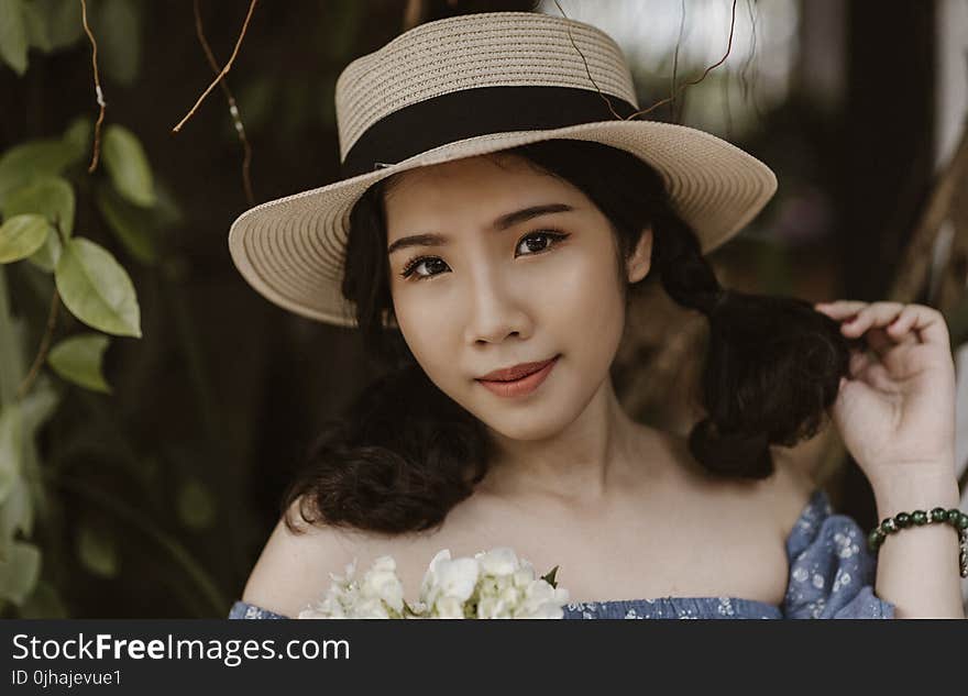 Focus Photography of Woman in Brown Sunhat Near Vine Plant