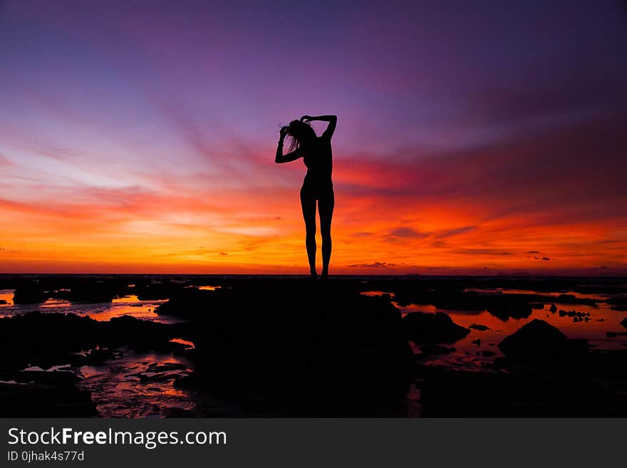 Silhouette of Woman Standing on Rock