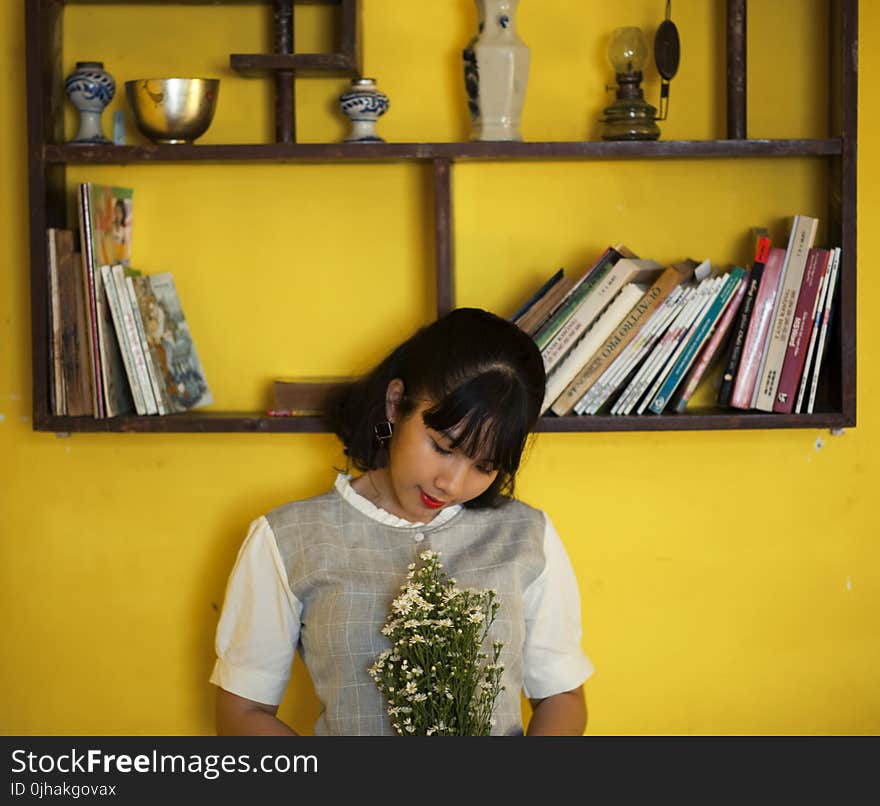 Woman Standing Beside Brown Wooden Shelf