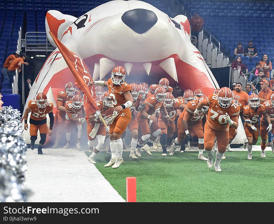 Football Team Running Thru Football Field