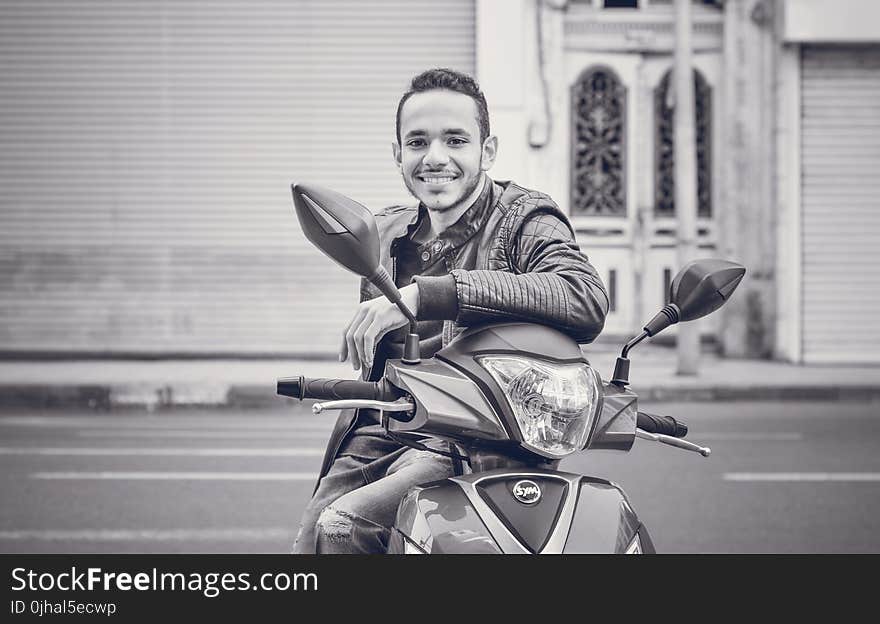 Grayscale Photography of Man Sitting on Motorcycle