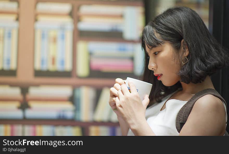 Photography of A Woman Holding White Coffee Mug