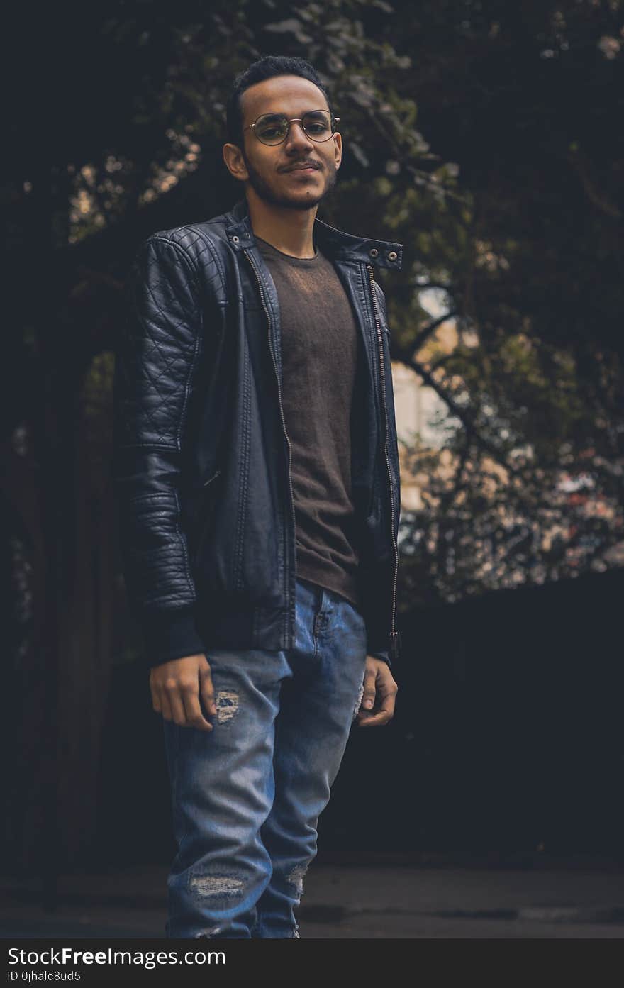 Man in Brown Shirt and Black Leather Zip-up Jacket and Blue Denim Pants