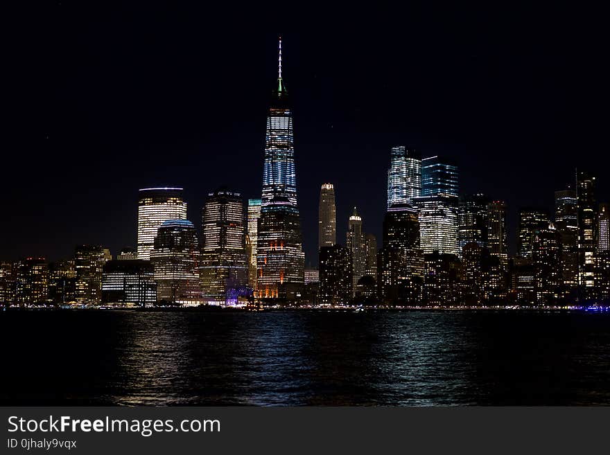 Skyline Beside the Body of Water at Night Time