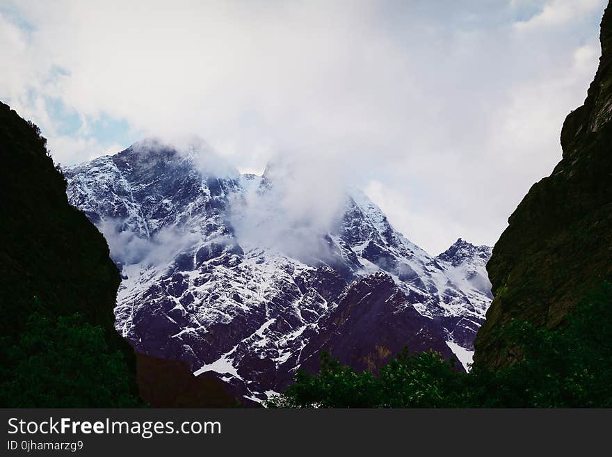 Snow Covered Mountain Under Cloudy Sky