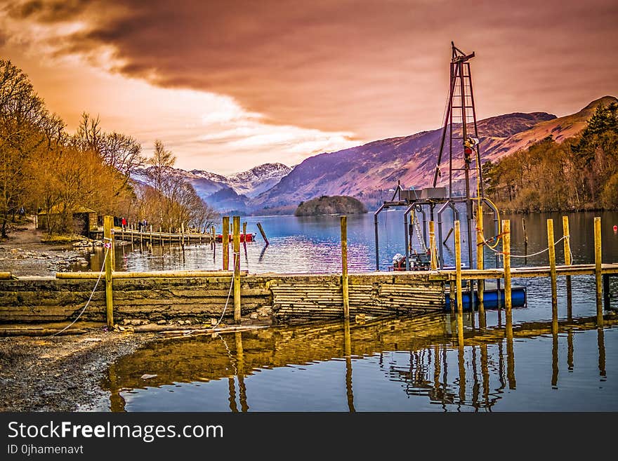 Brown Wooden Bridge Near Mountains and Body of Water