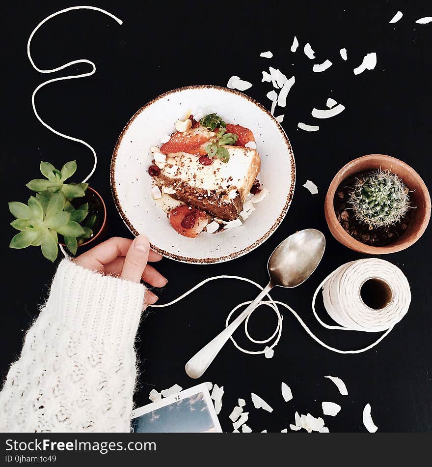 Woman Touching White and Brown Ceramic Saucer With Strawberry Cake