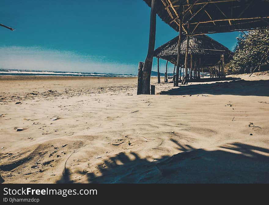 Brown Nipa Cottage Near Ocean at Daytime