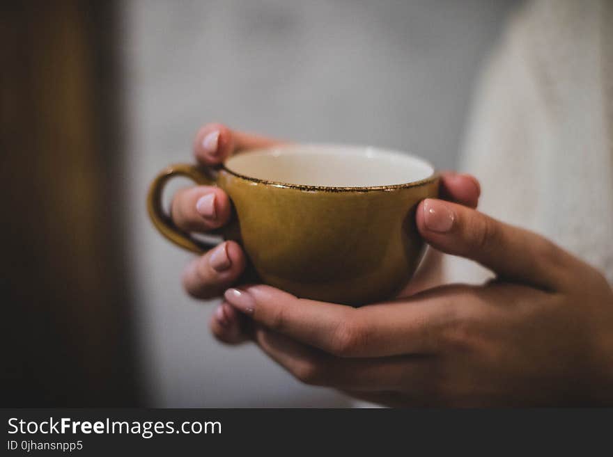 Person Holding Yellow Ceramic Cup