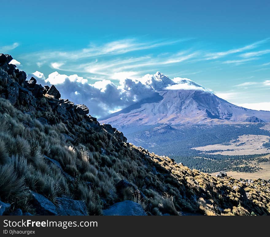 Brown Mountain Under White Clouds and Blue Sky