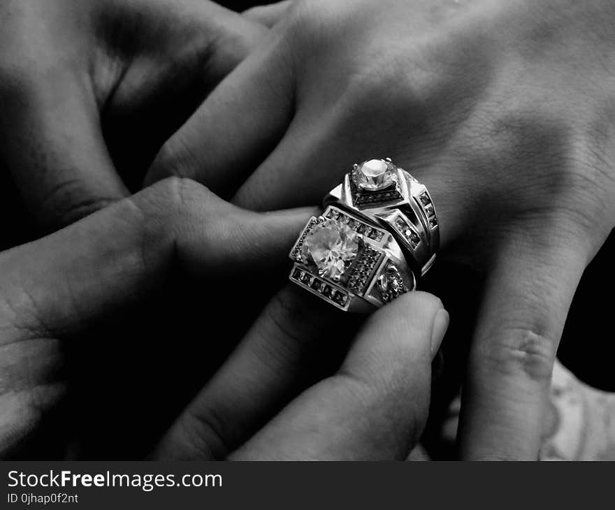 Grayscale Photo of Person Wearing Two Diamond-encrusted Rings