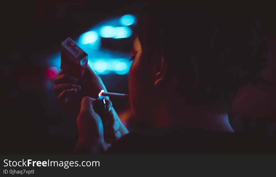 Man Lighting Up a Cigarette during Nighttime in Tilt Shift Lens Photograhy