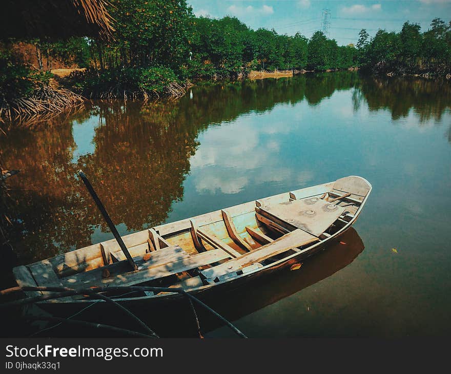 Brown Canoe Boat on Body of Water