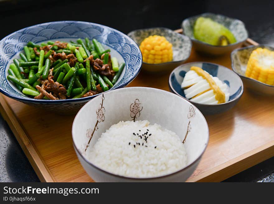 Rice on Bowl, Sliced-egg, Corn, and Vegetable on Table