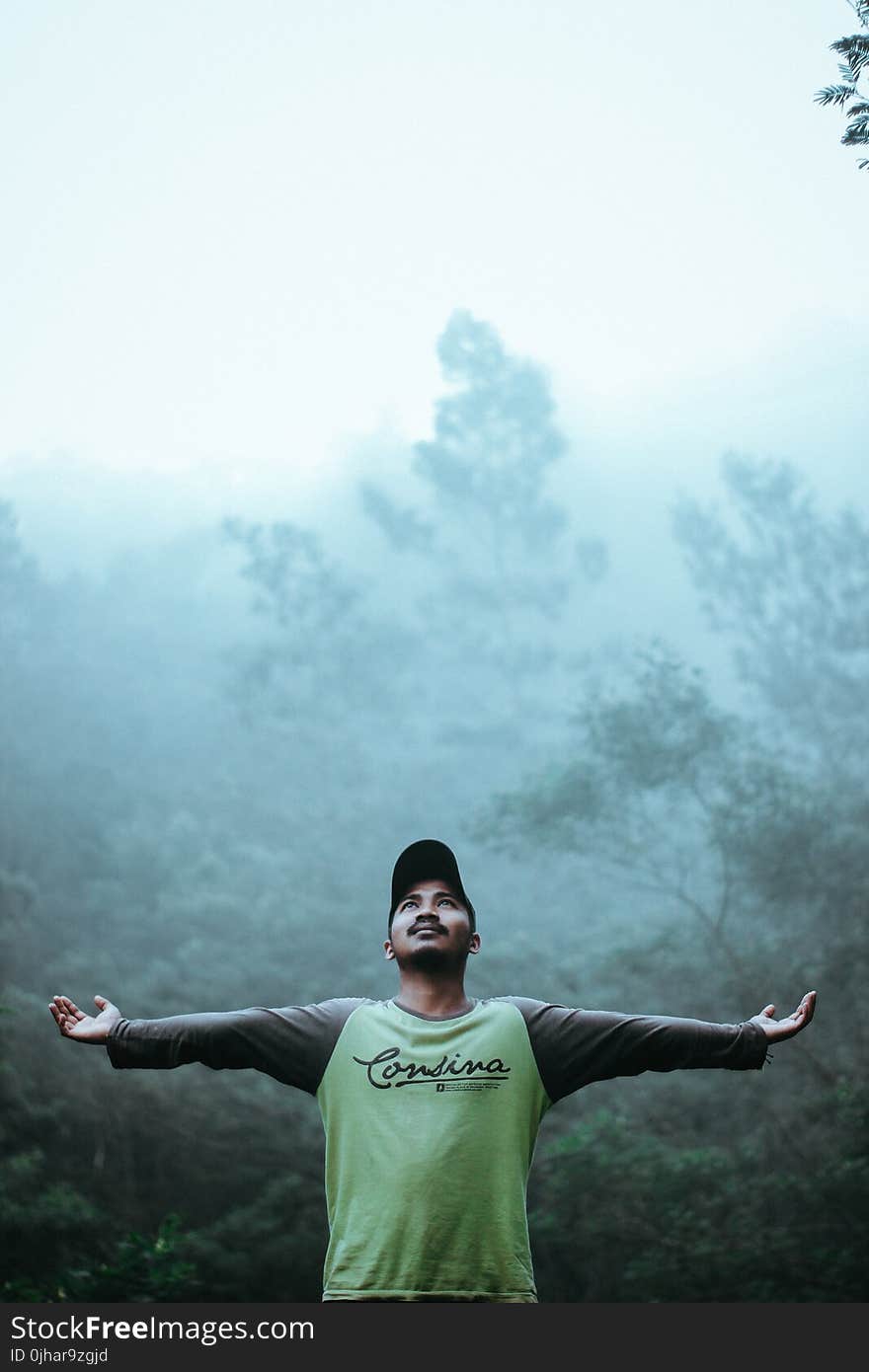 Man Wearing Black and Green Long Sleeve Shirt and Cap